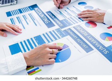 Business people discussing the charts and graphs showing the results of their successful teamwork - Shutterstock ID 344260748
