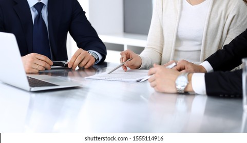 Business People Discussing Contract Working Together At Meeting At The Glass Desk In Modern Office. Unknown Businessman And Woman With Colleagues Or Lawyers At Negotiation. Teamwork And Partnership