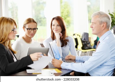 Business people discussing financial plans and working on laptop and tablet. Teamwork.