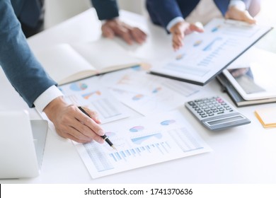 Business People Discussing With Sales Report Calculating A Data Reference.