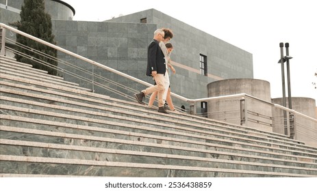 Business people discussing while descending stairs in city - Powered by Shutterstock