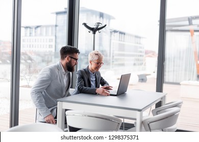 Business People Discussing Work Related Matters, Working On A Laptop Computer