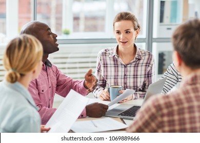 Business people discussing work while sitting at the table at meeting