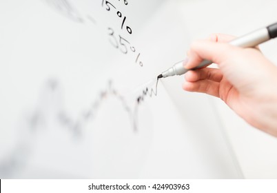business, people, economics, analytics and statistics concept - close up of hand with marker drawing graph on office white board
