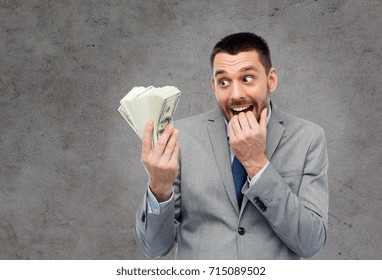 Business, People And Finances Concept - Astonished Or Greedy Businessman With Bundle Of American Dollar Cash Money Over Gray Concrete Background