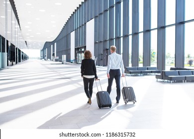 Business people in formal clothing walking with wheeled bags at airport terminal - Powered by Shutterstock