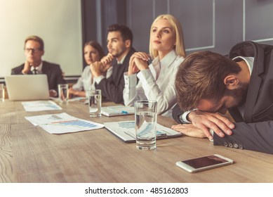 Business people in formal wear are participating in the conference, man in the foreground is leaning on his hands - Powered by Shutterstock