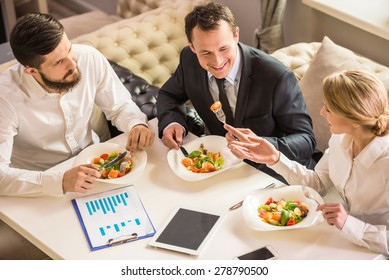 Business people in formalwear discussing something during business lunch. - Powered by Shutterstock