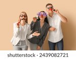 Business people in funny disguise with party whistles on beige background. April Fools