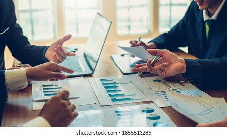 Business People Gather To Analyze Marketing And Investment Information And Pointing To Financial Data Chart At Meeting.