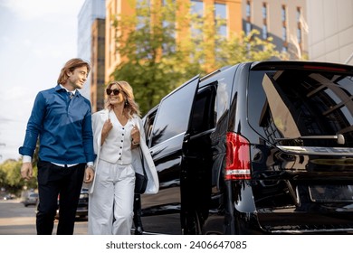 Business people get out of a minivan taxi, during a business trip by car. Concept of business trips and transportation