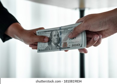 Business People Giving Bribe Money Under Table To Hand Of Their Partner To Give Success The Deal Contract In A Corruption, Illegal And Dishonest.