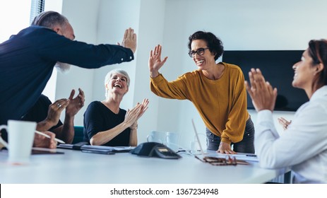 Business people giving each other high five and clapping. Business team celebrating success. - Powered by Shutterstock