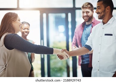 Business people giving handshake, welcoming new employee and standing united while colleagues clap in meeting at work. Coworkers shaking hands, celebrating success or congratulating on a promotion - Shutterstock ID 2188929743