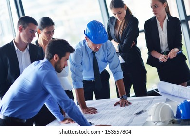 Business People Group On Meeting And Presentation  In Bright Modern Office With Construction Engineer Architect And Worker Looking Building Model And Blueprint Planbleprint Plans