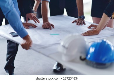 business people group on meeting and presentation  in bright modern office with construction engineer architect and worker looking building model and blueprint  plans