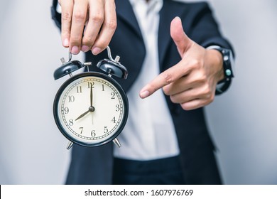 business people hand finger pointing at clock times at 8 o'clock, reminder time to do something or timing notice concept - Shutterstock ID 1607976769