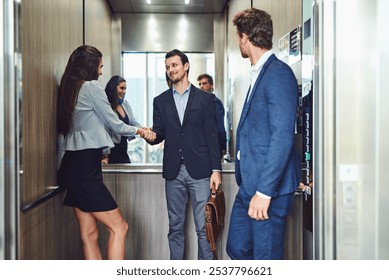 Business people, handshake and elevator with colleagues for meeting, introduction or welcome in office building. Happy, businessman or employees shaking hands for greeting or collaboration in lift - Powered by Shutterstock