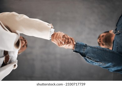 Business people, handshake and meeting in partnership, teamwork or trust for unity below at office. Low angle of employees shaking hands for introduction or greeting in agreement or deal at workplace