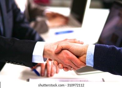 Business people handshake, sitting at the table