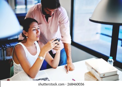 Business people having conversation while working in modern loft co-working space, young asian woman holding her smart phone while talking with her colleague, students in library using technology