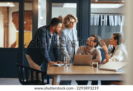 Business people having a meeting in a digital marketing agency. Group of business professionals discussing a project in an office. Teamwork and collaboration in a creative workplace.