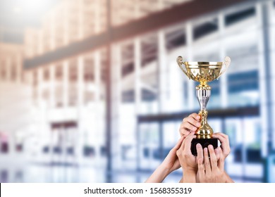 Business People Holding Gold Trophy Award For Celebrate 
Together