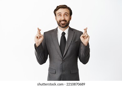 Business people. Hopeful worried corporate man praying, holding fingers crossed and making wish, anticipating result, standing over white background - Powered by Shutterstock