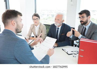 Business people interviewing male applicant at office - Powered by Shutterstock