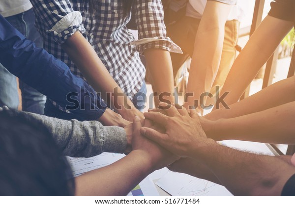 Business\
people join hand together during their\
meeting