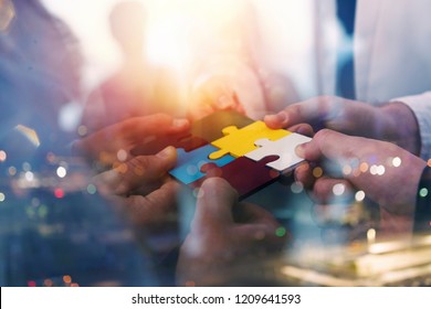 Business people join puzzle pieces in office. Concept of teamwork and partnership. double exposure with light effects - Shutterstock ID 1209641593