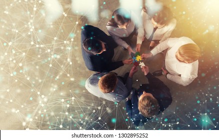 Business people join puzzle pieces in office. Concept of teamwork and partnership. double exposure with internet network effects