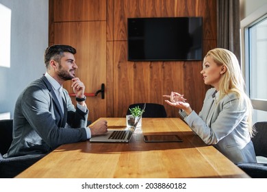 Business People With A Laptop And Tablet Sit In A Modern Boardroom With Natural Light And Have A Brainstorming Meeting. They Talk About Improving The Business. Cooperation, Business Meeting