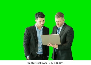 Business people looking at virtual screens and a laptop with solid green screen background - Powered by Shutterstock