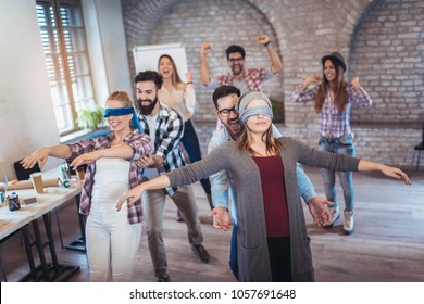 Business people making team training exercise during team building seminar, play a game of trust - Shutterstock ID 1057691648