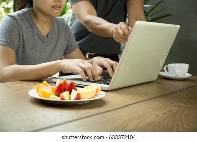 Business People Man And Woman Team Work With Laptop With Fresh Fruit On The Table