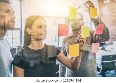 Business people meeting at office and use post it notes to share idea. Brainstorming concept. Sticky note on glass wall. - Shutterstock ID 1118944184