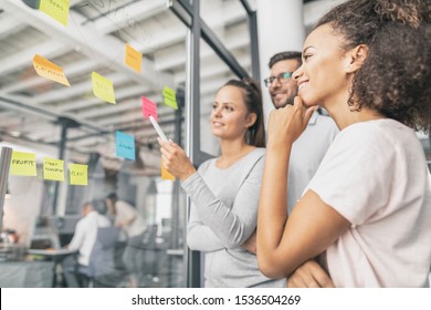 Business People Meeting At Office And Use Post It Notes To Share Idea. Brainstorming Concept. Sticky Note On Glass Wall.