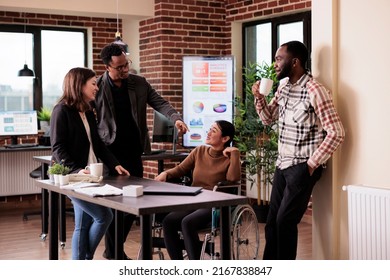 Business people meeting on break in disability friendly office, laughing with asian woman. Female wheelchair user with physical health condition chatting with work colleagues. - Powered by Shutterstock - Get 15% off with code: PIKWIZARD15