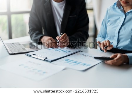 Business people meeting to plan the financial market looking at past quarterly company graph and chart to compare investment and analyze company revenue and marketing strategy.
