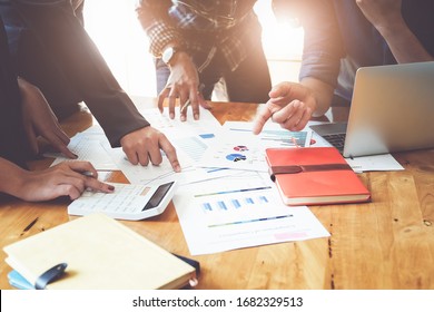 Business People Meeting using laptop computer, calculator,notebook,stock market chart paper for analysis Plans to improve quality next month. Conference Discussion Corporate Concept
