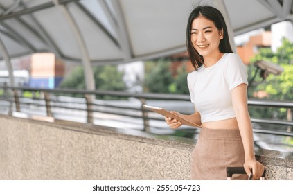 Business people modern urban lifestyles with technology. Asian woman using digital tablet for internet browsing or app. Wearing brown suit casual cloth. City background. - Powered by Shutterstock