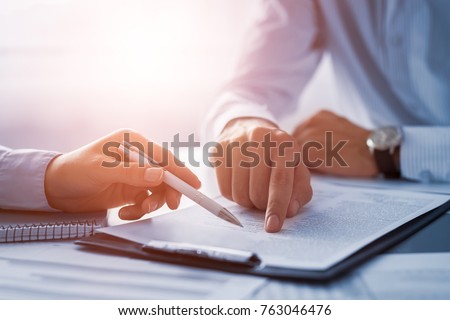 Business people negotiating a contract. Human hands working with documents at desk and signing contract.