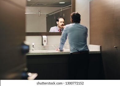 Business People In Office Bathroom. Young Man Using Corporate Restroom, Washroom And Lavatory. Public Toilet In Building With Manager Brushing Teeth After Lunch Break