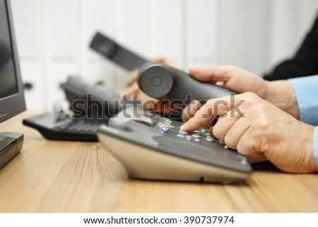 business people in office calling customers on land line telephones