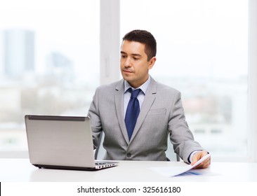 Business, People, Paperwork And Technology Concept - Businessman With Laptop Computer And Papers Working In Office