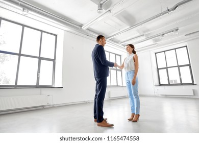 business people, partnership and cooperation concept - happy smiling businesswoman and businessman shaking hands at office - Shutterstock ID 1165474558