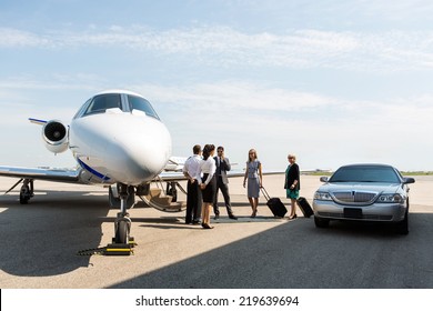 Business People With Pilot And Airhostess Standing Near Private Jet And Limo At Terminal