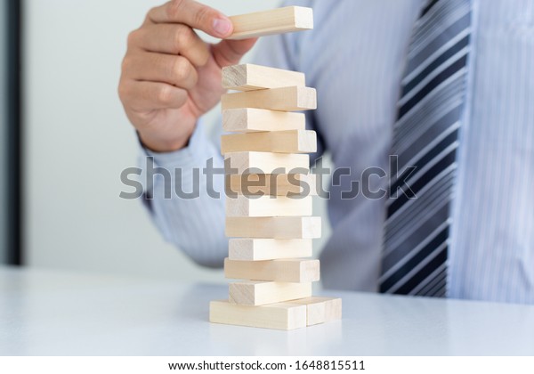 Business people play wooden\
games together, divide the average investment value of a business\
and jointly manage risks, Alternative risk plan and strategy in\
business.