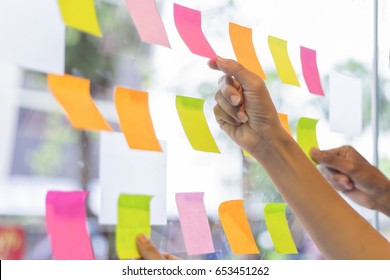business people post it notes in glass wall at meeting room - Shutterstock ID 653451262